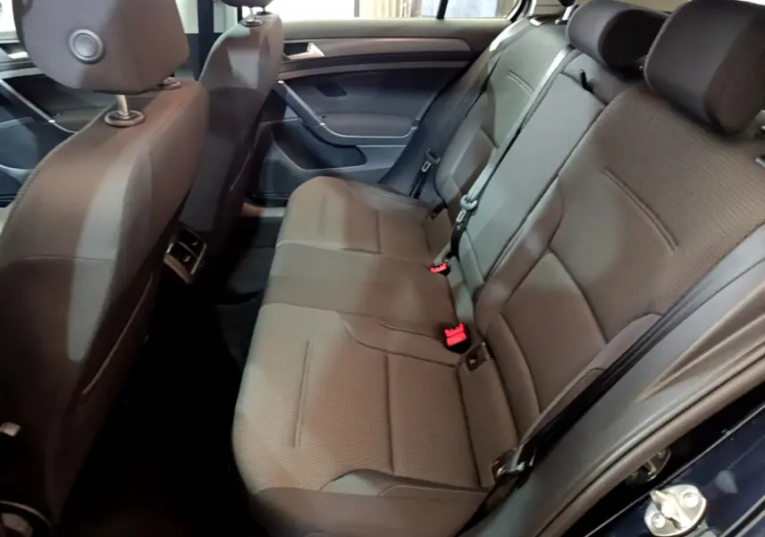 Vue intérieure côté droit sur la banquette arrière grise de la Volkswagen Golf 1.6 TDI 2018 avec appuie-têtes et ceintures visibles.