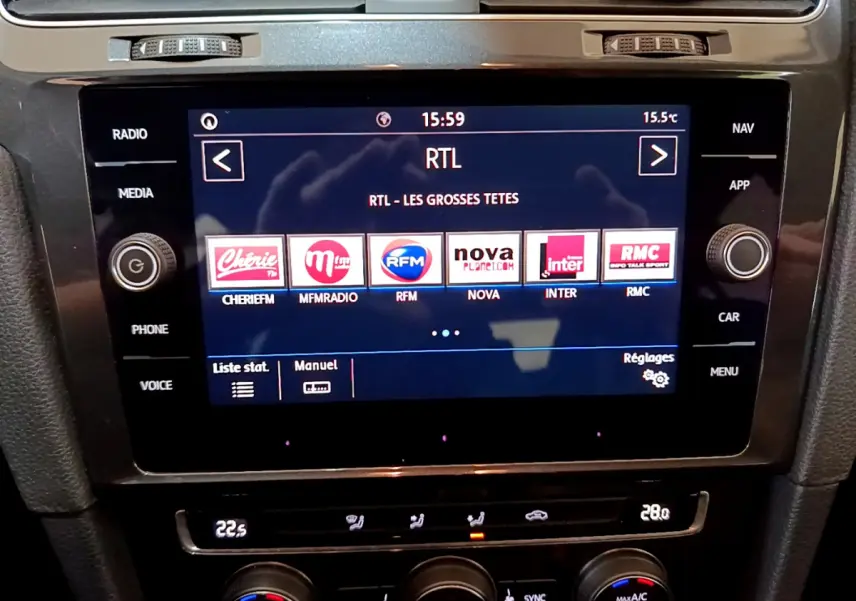 Écran tactile central de la Volkswagen Golf noire 2018 affichant les stations radio avec commandes climatisation en dessous.