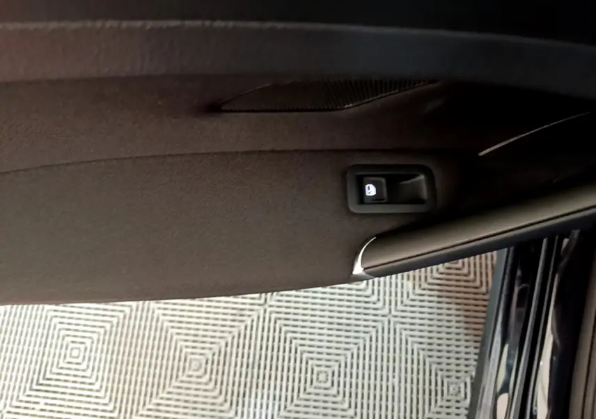 Poignée intérieure de la porte côté droit d'une Volkswagen Golf noire, vue en gros plan depuis l'intérieur.