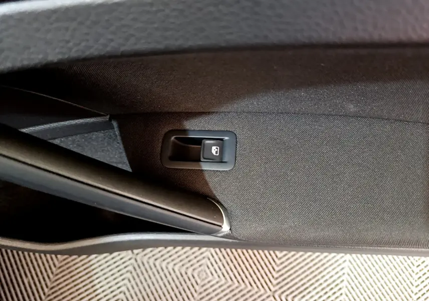 Détail de la poignée d'ouverture intérieure du coffre sur la porte arrière droite d'une Volkswagen Golf noire 2018.