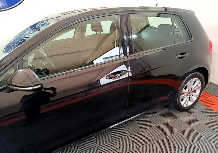 Profil côté gauche d'une Volkswagen Golf noire 2018 avec jantes alliage et rétroviseurs noirs brillants.