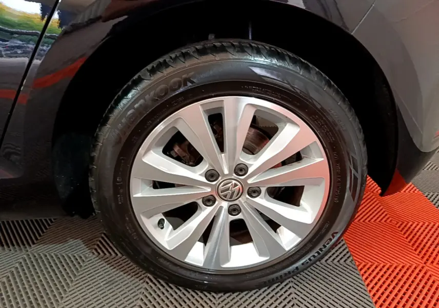 Gros plan sur la roue avant gauche avec jante argentée et pneu Hankook d'une Volkswagen Golf noire.