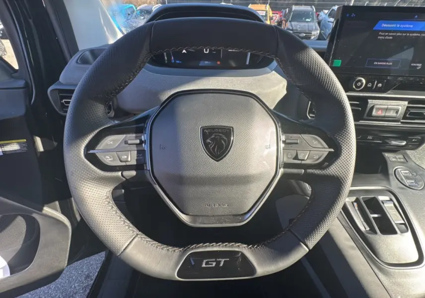 Volant cuir multifonctions noir avec logo Peugeot et badge GT, tableau de bord et écran tactile du Peugeot Rifter 2025.
