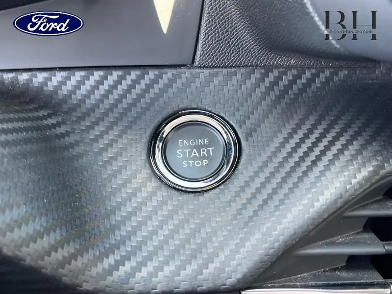 Bouton start/stop moteur sur tableau de bord effet carbone, intérieur d'une Peugeot 208 blanc Banquise 2021.