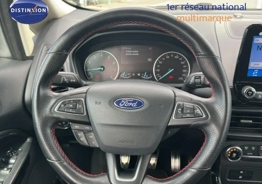 Vue rapprochée du volant en cuir noir avec surpiqûres rouges du Ford EcoSport gris clair, tableau de bord et écran tactile visibles.