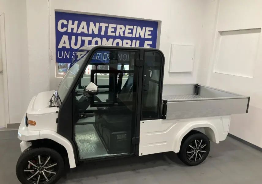 Vue de profil droit du véhicule utilitaire électrique LIBERTY L7E H2 160 blanc avec kit ridelles et jantes alliage 13 pouces.