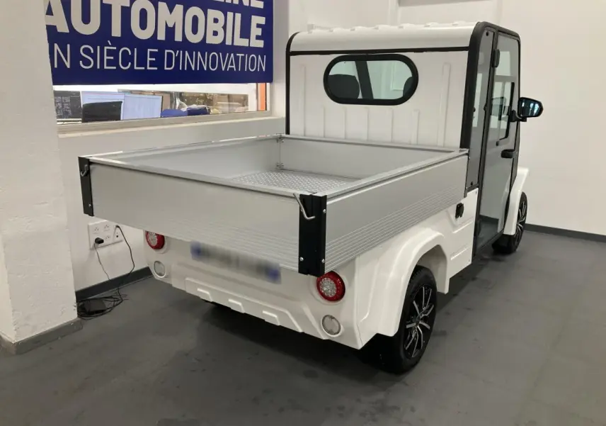 Vue 3/4 arrière droite du pick-up électrique Liberty L7E H2 160 blanc avec kit ridelles et jantes alliage 13 pouces.