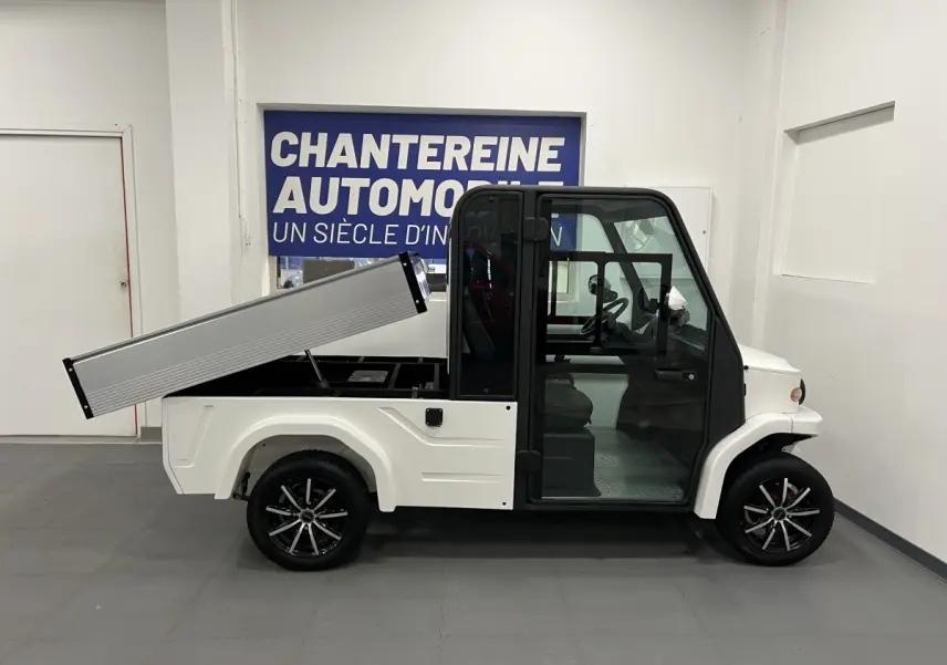 Vue de profil droit du Liberty L7E H2 160 blanc 2026 avec kit ridelles relevé et jantes alliage 13 pouces.
