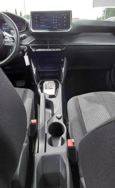 Vue intérieure centrée sur la console centrale et tableau de bord noir du Peugeot 2008 Hybrid 145 e-DCS6 Style 2025.