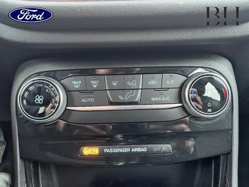 Gros plan sur la console de climatisation du Ford Puma 2023 avec boutons de réglage et indicateur airbag passager allumé.