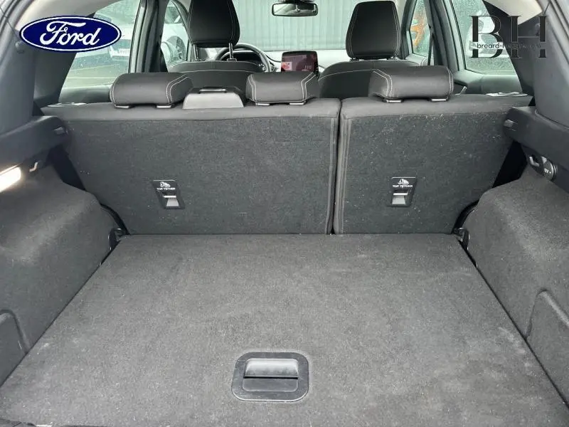 Vue intérieure du coffre du Ford Puma 2023 gris Solar Métallisée, avec banquette arrière et sièges en tissu noir Kasbah visibles.