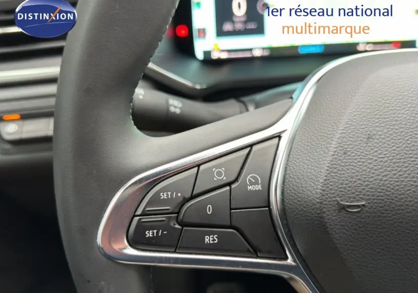 Gros plan sur les commandes au volant du Renault Captur 2025, finition TECHNO, avec tableau de bord numérique en arrière-plan flou.