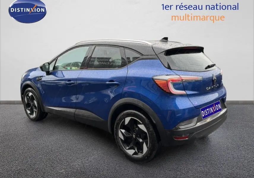 Vue 3/4 arrière droite du Renault Captur 2025 bleu Iron Metal avec toit noir et jantes stylisées bicolores.