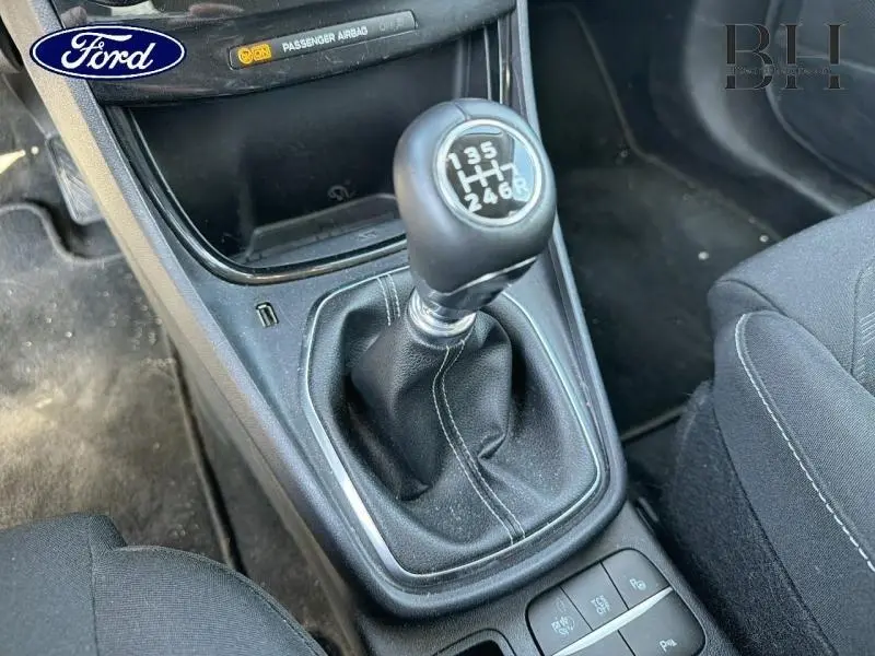 Gros plan sur le levier de vitesses manuel noir du Ford Puma 2024, avec coutures visibles et console environnante.