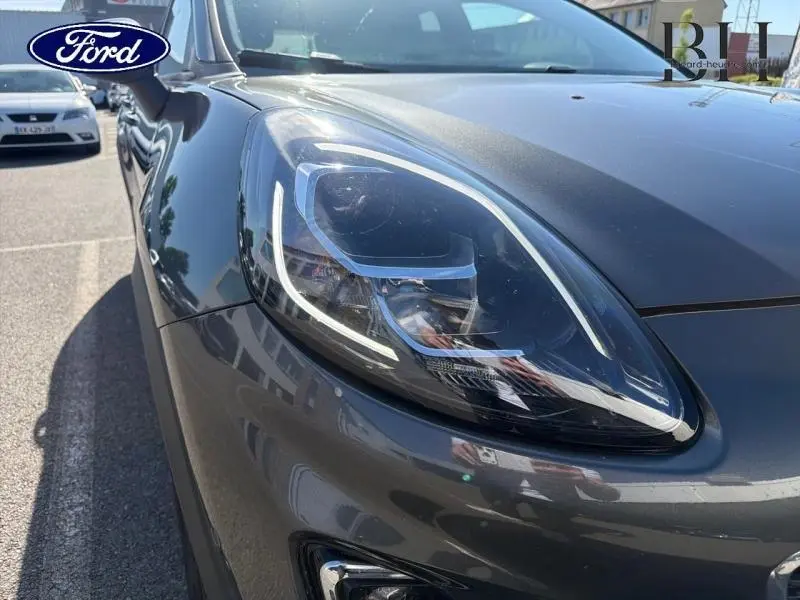 Gros plan sur le phare avant droit du Ford Puma 2024 en gris métallisé Fashion Gris Magnetic, soulignant ses lignes modernes.