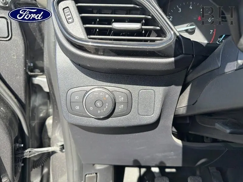 Détail du tableau de bord côté gauche du Ford Puma 2024 gris, avec commandes d'éclairage et ventilation.