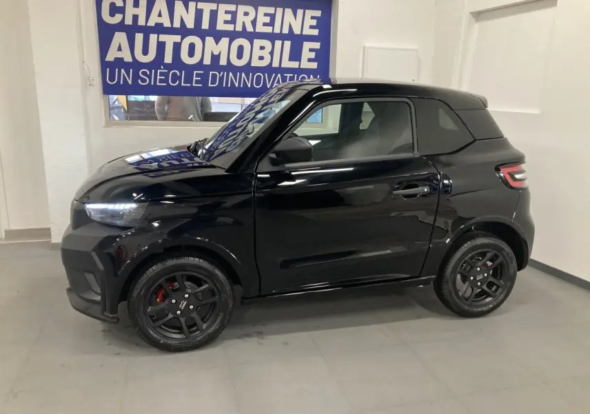 Vue de profil côté gauche d'une LIGIER JS50 0.5 REVO D+ SELECT noire avec jantes alu noires et feux LED visibles.