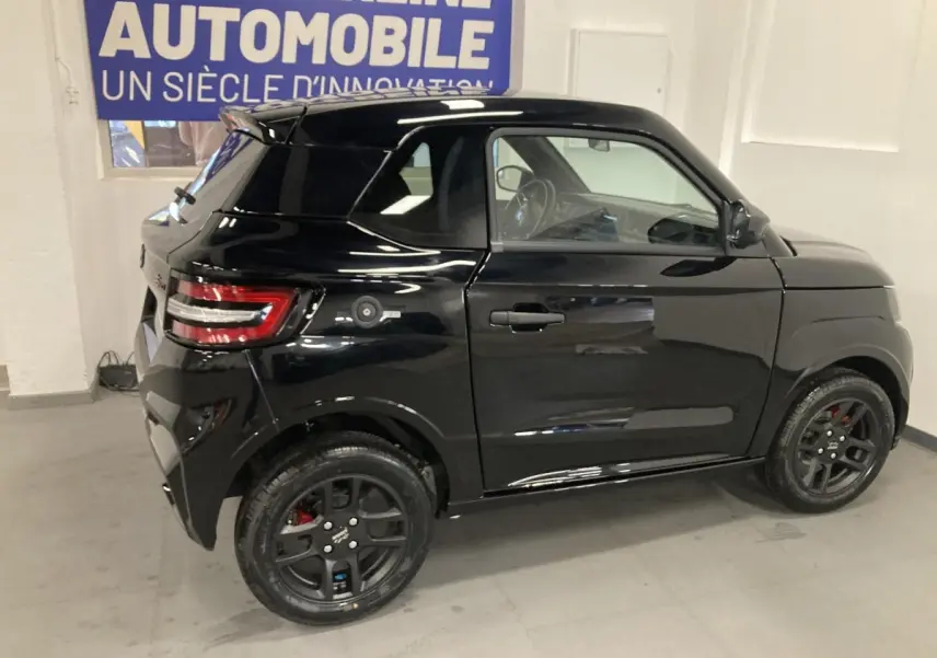 Vue de profil droit d'une LIGIER JS50 0.5 REVO D+ SELECT noire avec jantes alu noires et feux arrière LED en intérieur.