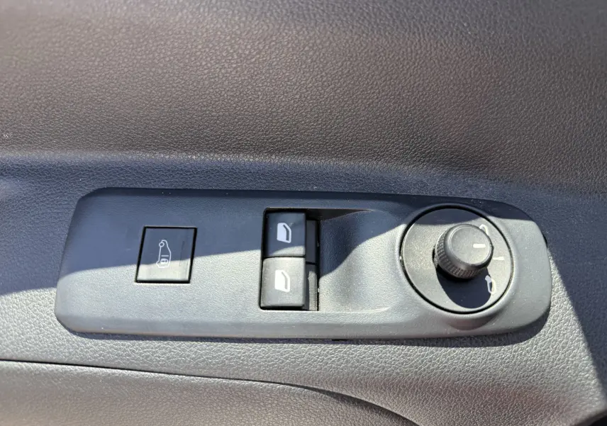 Gros plan sur les commandes de réglage des rétroviseurs et des vitres côté conducteur du Citroën Berlingo blanc banquise 2022.