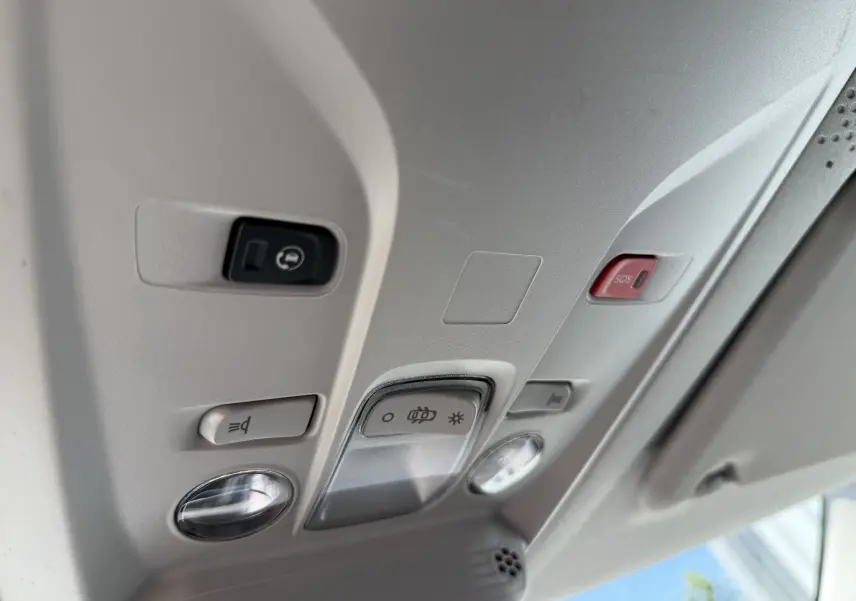Détail du plafonnier intérieur gris clair du Citroën Berlingo XL blanc, avec boutons d’éclairage et alerte SOS.