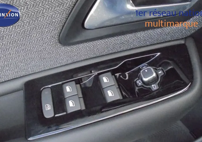 Gros plan sur les commandes des vitres et rétroviseurs côté gauche dans l'habitacle d'une Citroën C5 X blanche 2023.