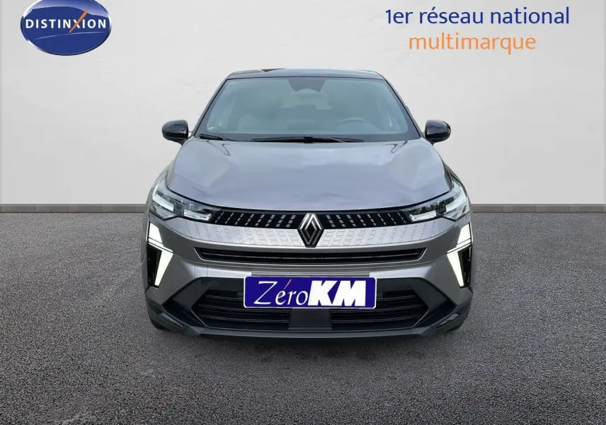 Vue frontale du Renault Captur gris Cassiopée métal avec toit noir et feux LED allumés sur fond neutre.
