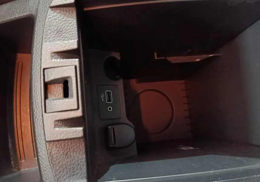 Gros plan sur la prise USB et prise jack dans le compartiment de rangement intérieur du Nissan Qashqai gris clair.