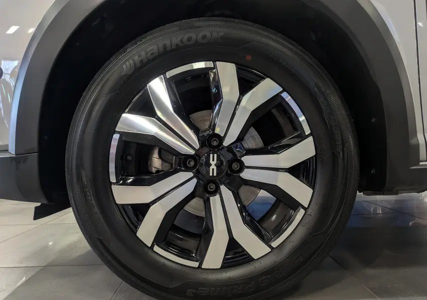 Gros plan sur la roue avant droite d'une Dacia Sandero Stepway gris Moonstone avec jante alliage bicolore brillante.