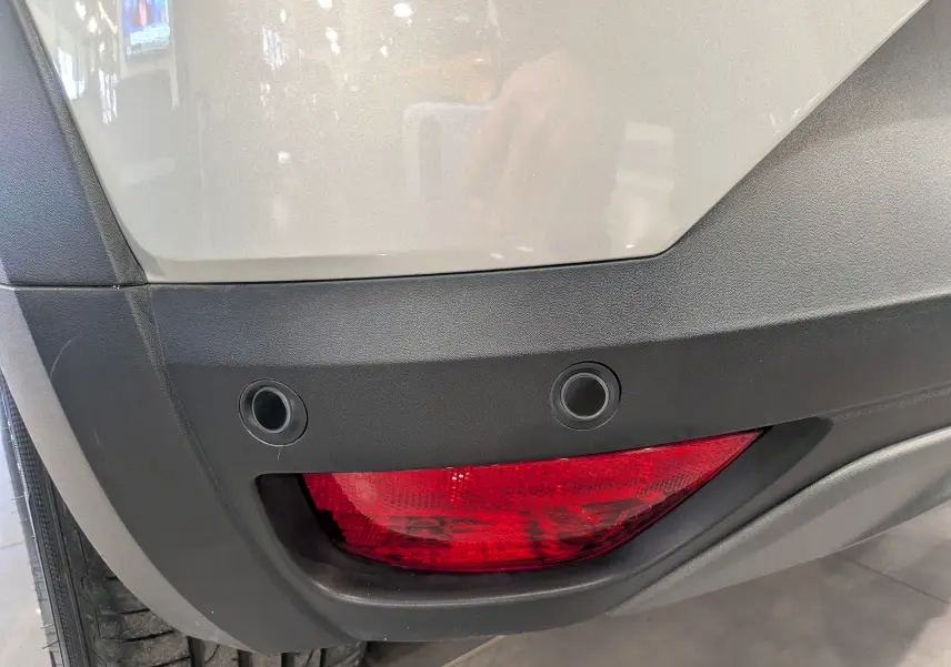 Gros plan sur le feu arrière droit rouge et le pare-chocs gris Moonstone d'une Dacia Sandero Stepway 2023.