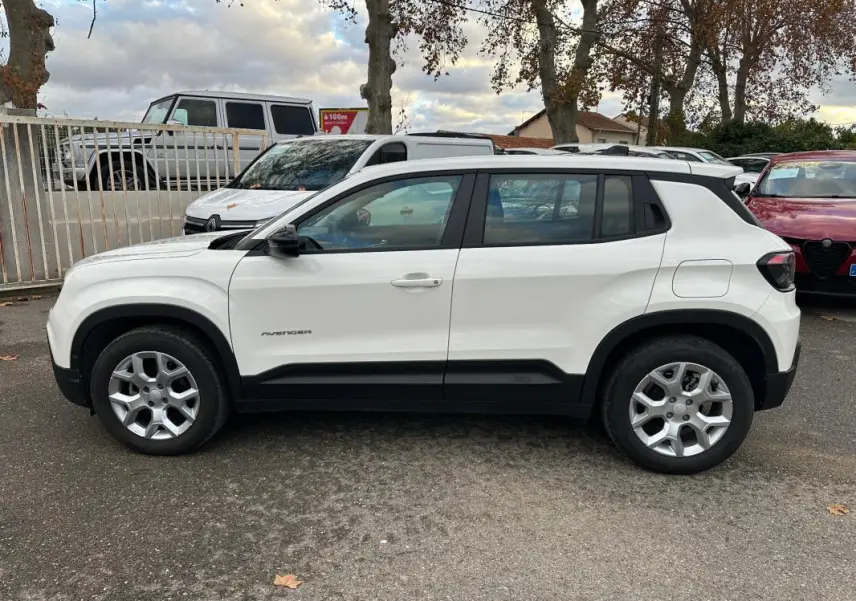 Vue de profil côté gauche d'un Jeep Avenger blanc 2024 avec jantes alliage 17 pouces et poignées de porte ton carrosserie.