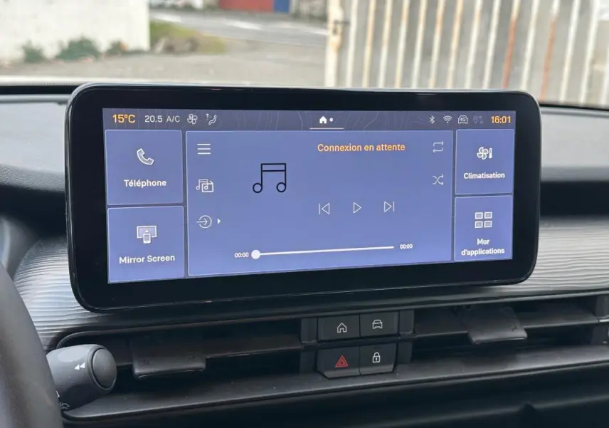Écran tactile central du tableau de bord du Jeep Avenger blanc, affichant les options multimédia et climatisation.
