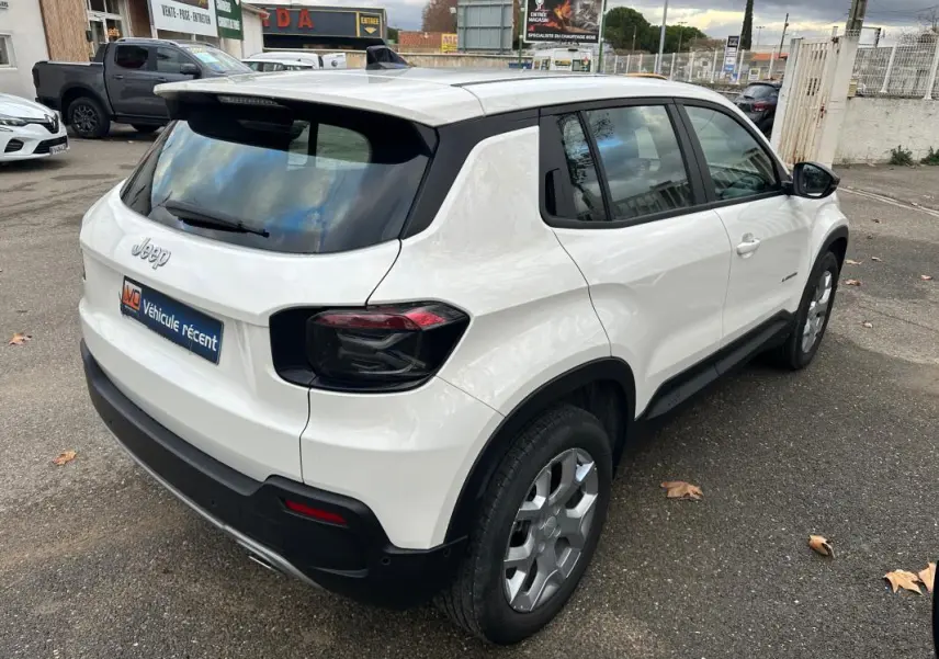 Vue 3/4 arrière droite d’un Jeep Avenger blanc 2024 avec jantes alliage 17 pouces et vitres teintées.