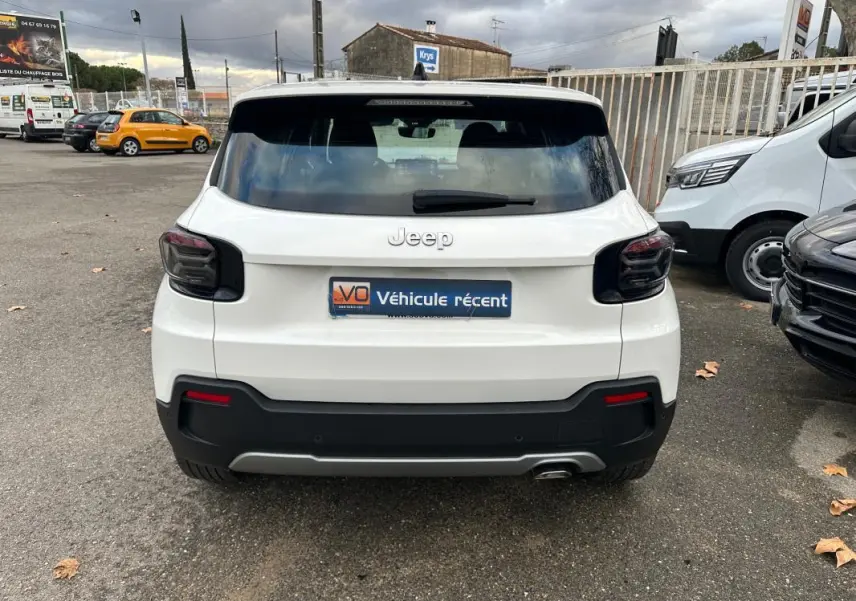 Vue arrière d'un Jeep Avenger blanc 2024 avec feux arrière fumés et pare-chocs noir contrastant.