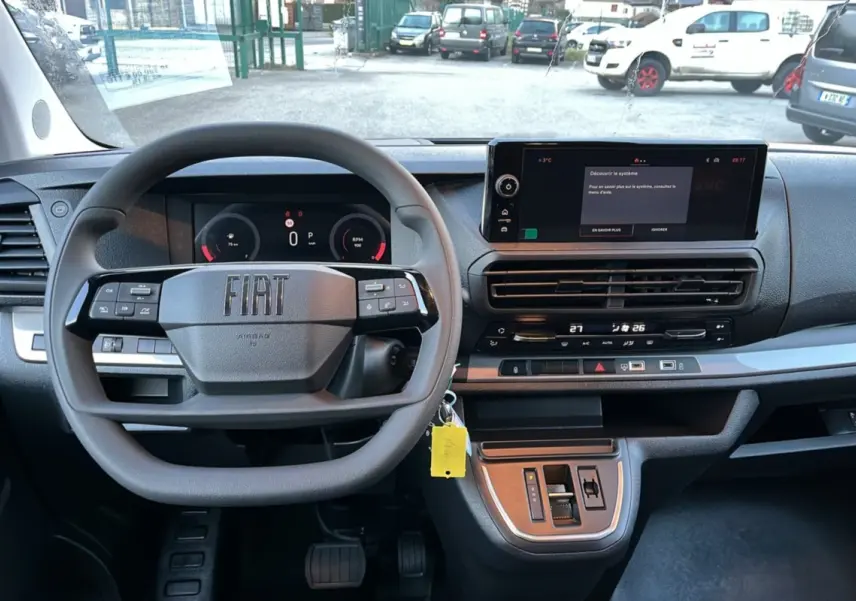 Vue intérieure frontale du tableau de bord noir du Fiat Scudo Fourgon 2025 avec volant multifonctions et écran tactile.