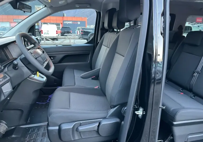Vue intérieure côté gauche du FIAT Scudo Fourgon noir 2025, montrant les sièges avant et arrière en tissu gris.
