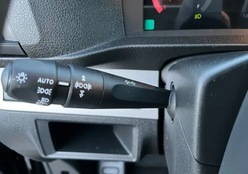 Gros plan sur la manette des feux et clignotants du tableau de bord du Fiat Scudo Fourgon noir, version 2025.