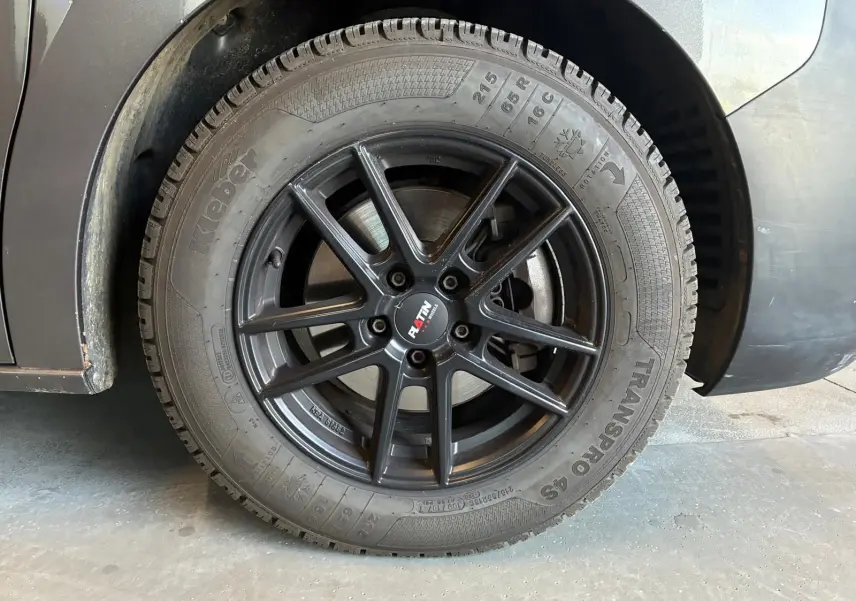 Gros plan sur la roue arrière droite du Citroën Jumpy gris, avec jante noire à dix branches et pneu hiver.