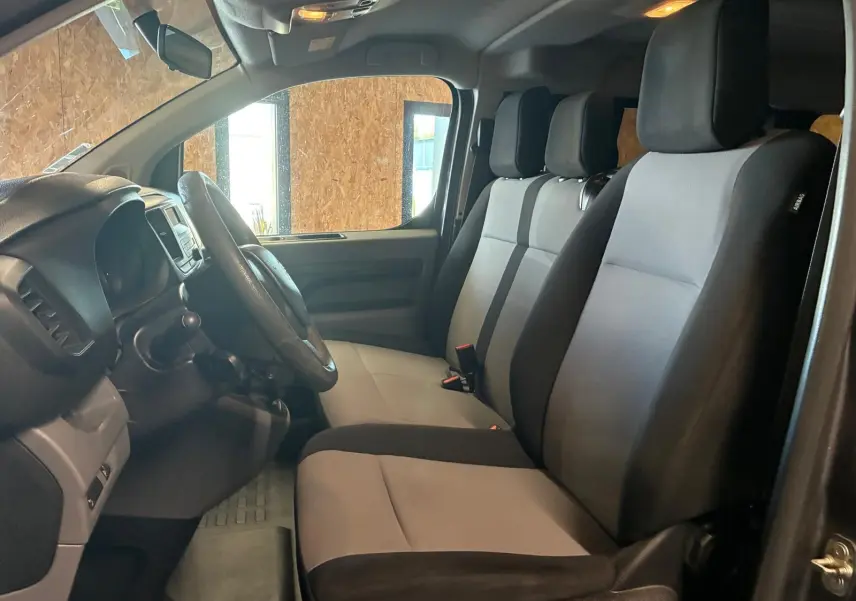 Vue intérieure côté conducteur du Citroën Jumpy XL Spacetourer 2017, sièges tissu gris et noir, volant et tableau de bord visibles.