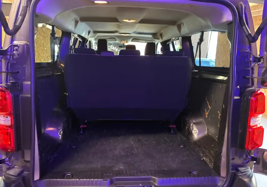 Vue arrière ouverte du Citroën Jumpy XL Spacetourer gris, montrant l'espace de chargement et les sièges arrière.