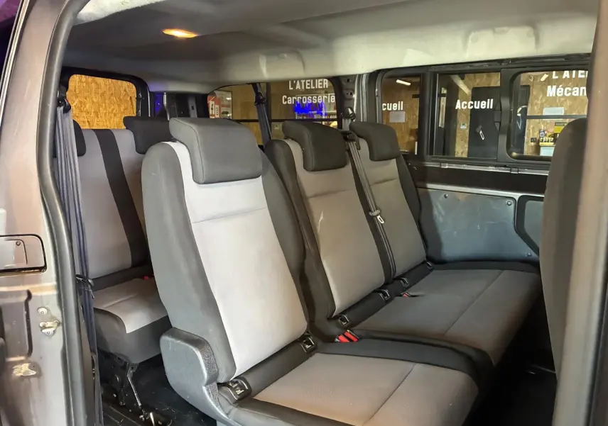 Vue intérieure côté gauche montrant les sièges tissu gris et noir du Citroën Jumpy XL Spacetourer 9 places.