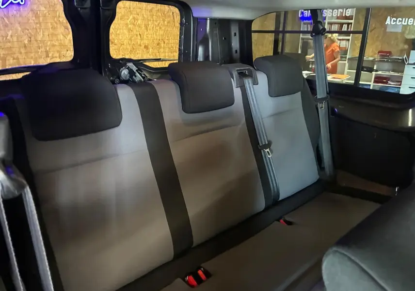 Vue intérieure arrière du Citroën Jumpy XL Spacetourer 2017, montrant les sièges tissu gris à trois places avec ceintures de sécurité.