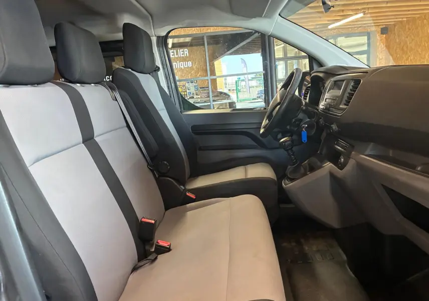 Vue intérieure côté conducteur du Citroën Jumpy XL Spacetourer 2017, sièges tissu gris clair et tableau de bord noir.