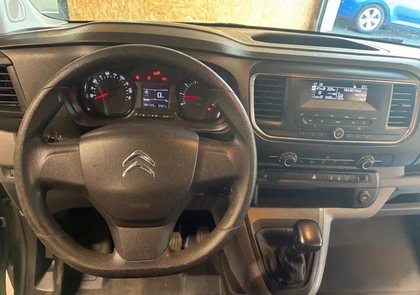 Vue intérieure centrée sur le volant noir et le tableau de bord du Citroën Jumpy XL Spacetourer gris de 2017 avec boîte manuelle.
