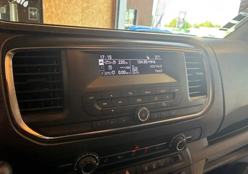 Vue rapprochée du tableau de bord du Citroën Jumpy gris, mettant en valeur l’écran central et les commandes radio.