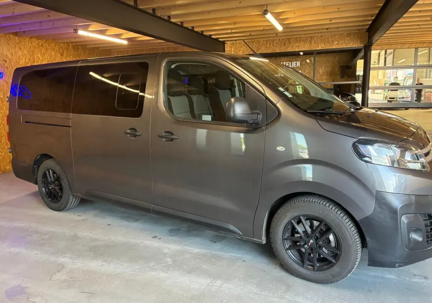 Vue latérale droite d'un Citroën Jumpy XL Spacetourer gris 2017 avec vitres teintées et jantes noires en intérieur.