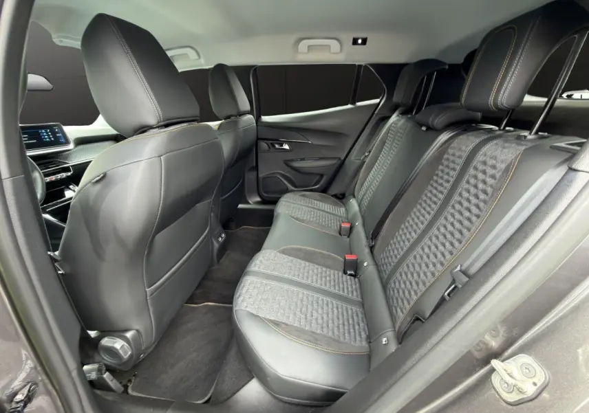 Vue intérieure arrière côté droit du Peugeot 2008 gris foncé, sièges mixtes cuir et tissu avec surpiqûres jaunes.