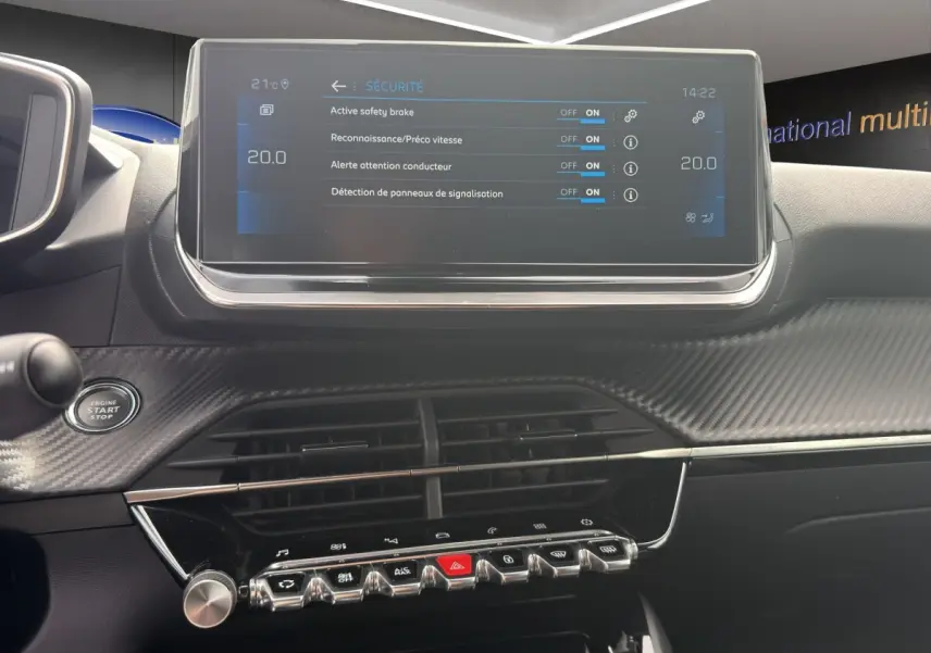 Vue rapprochée du tableau de bord de la Peugeot 2008 gris foncé, avec écran tactile et commandes de sécurité affichées.