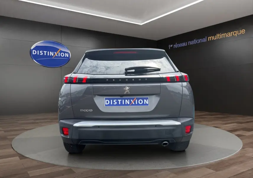 Vue arrière d'un Peugeot 2008 gris foncé 2022 avec feux LED caractéristiques et logo lion central visible.