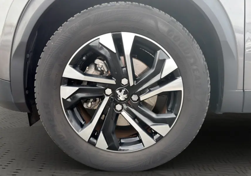 Gros plan sur la roue avant droite du Peugeot 2008 gris foncé avec jante alliage noire et argentée.