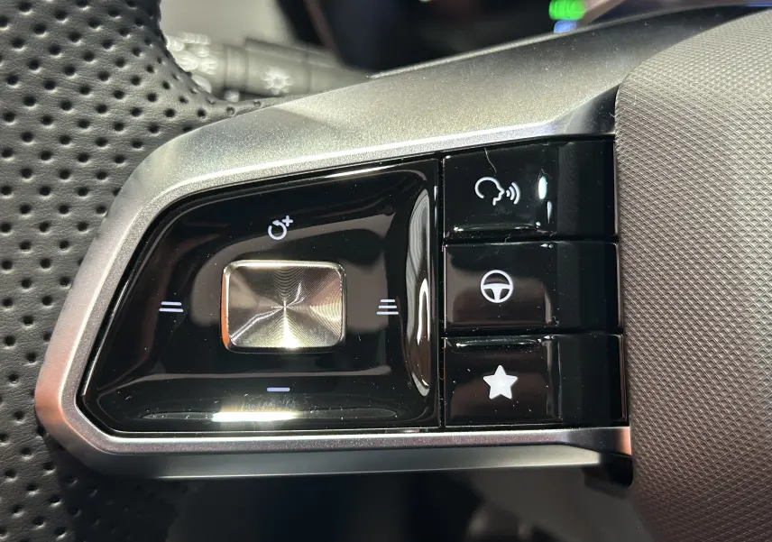 Gros plan sur les commandes noires et argentées au volant perforé du MG Motor ZS Hybrid+ 197 Luxury 2026.